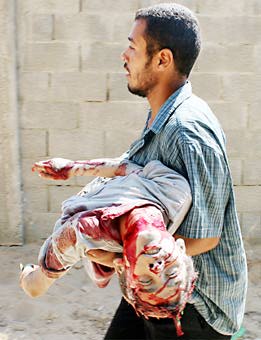 Palestino llevando el cadáver de un niño en Gaza