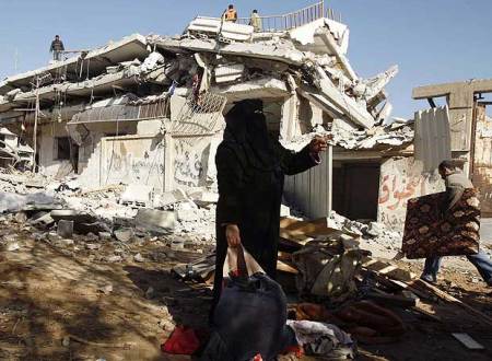 Mujer junto a los restos de su casa en Gaza